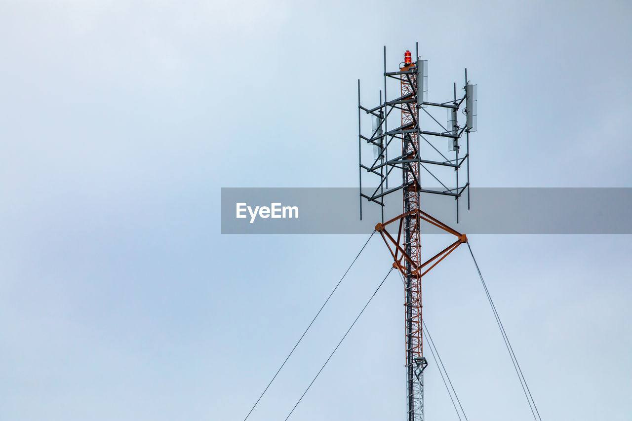 Low angle view of transmission tower against sky