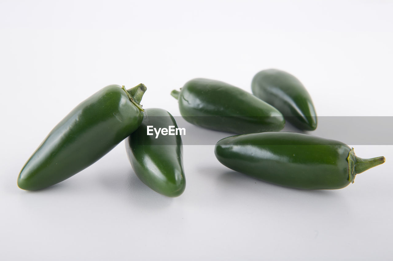 CLOSE-UP OF GREEN PEPPER OVER WHITE BACKGROUND