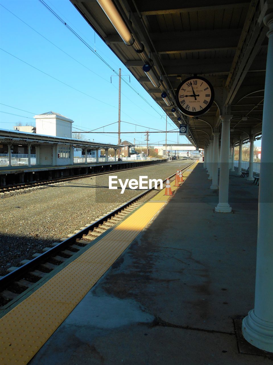 Empty railroad station platform against clear blue sky