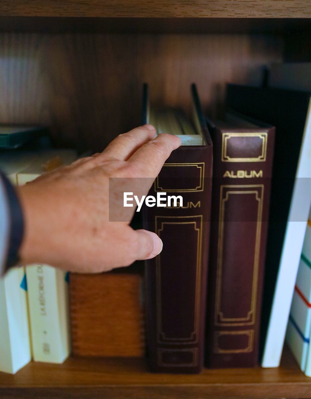 Close-up of human hand selecting a book