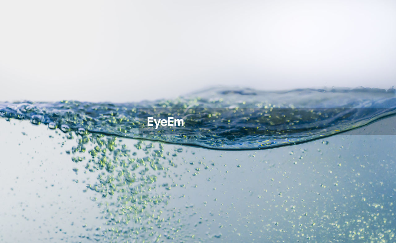 CLOSE-UP OF WATER DROPS ON WHITE BACKGROUND