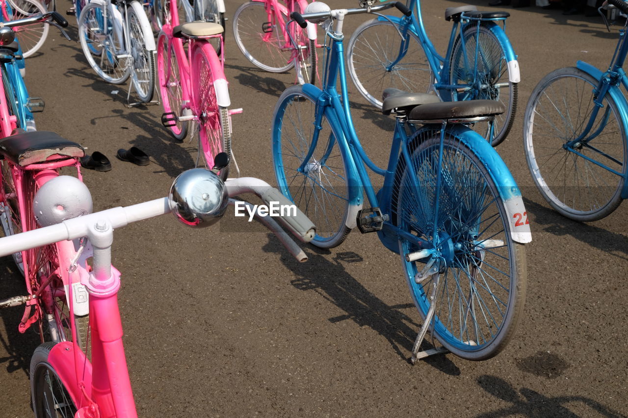 HIGH ANGLE VIEW OF BICYCLES PARKED ON ROAD