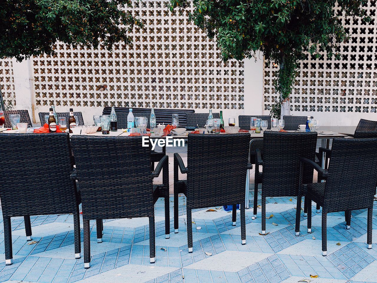 CHAIRS AND TABLES AT SIDEWALK CAFE AGAINST BUILDINGS IN CITY