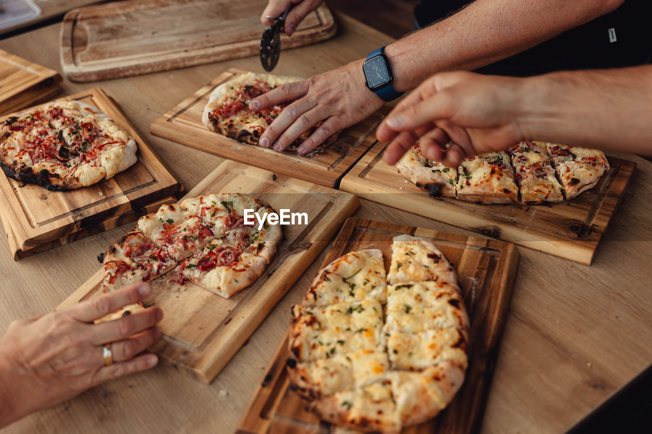 Person cutting pizza on table at home