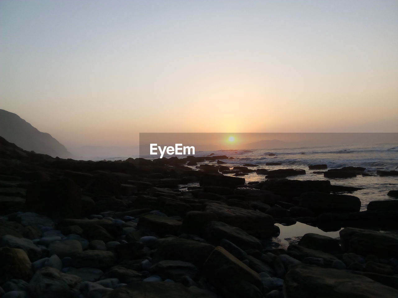 SCENIC VIEW OF SEA AGAINST SKY AT SUNSET