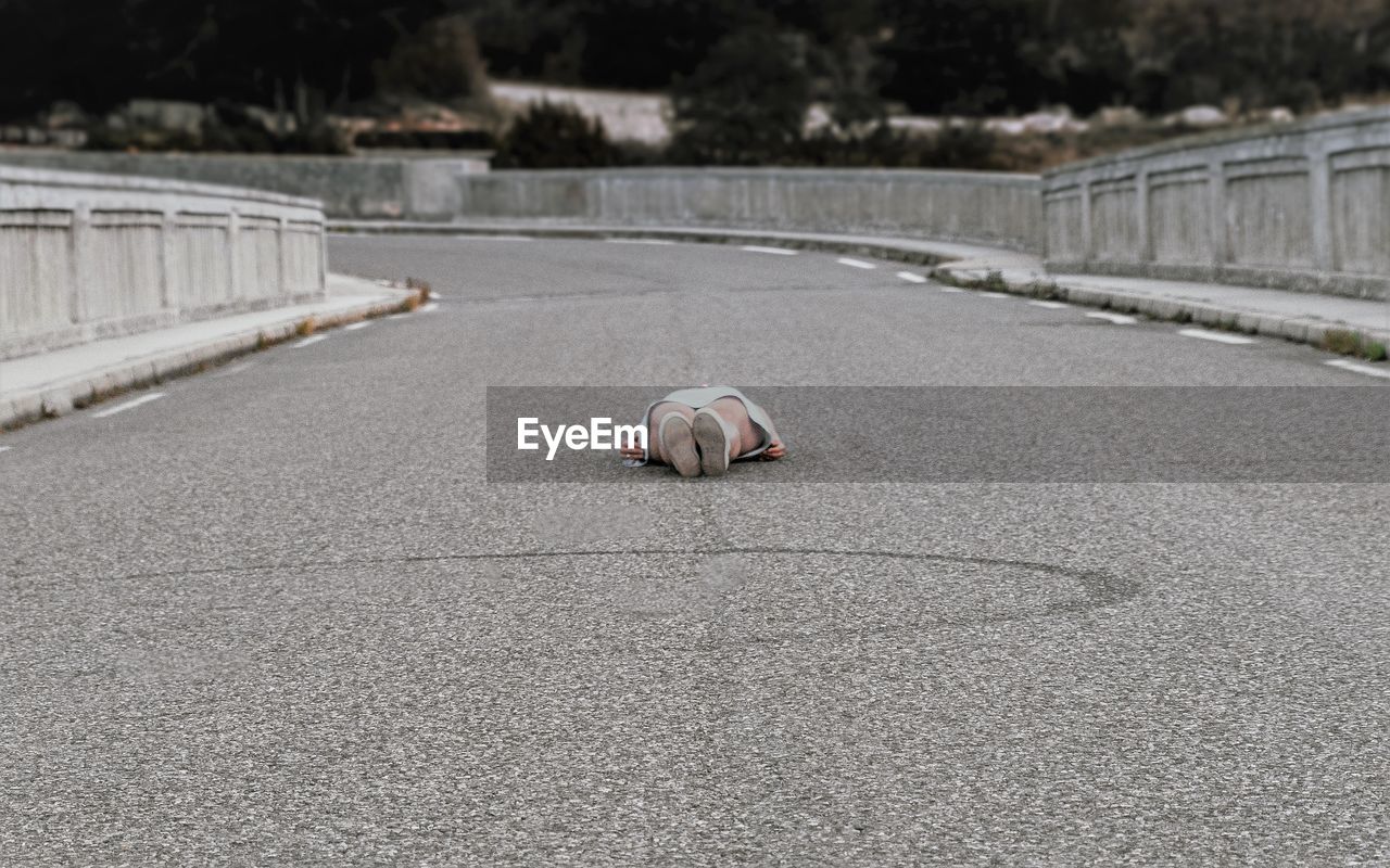 Low section of woman lying on road