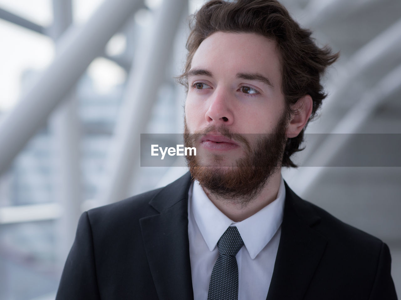 Close-up of thoughtful businessman looking away while standing in building