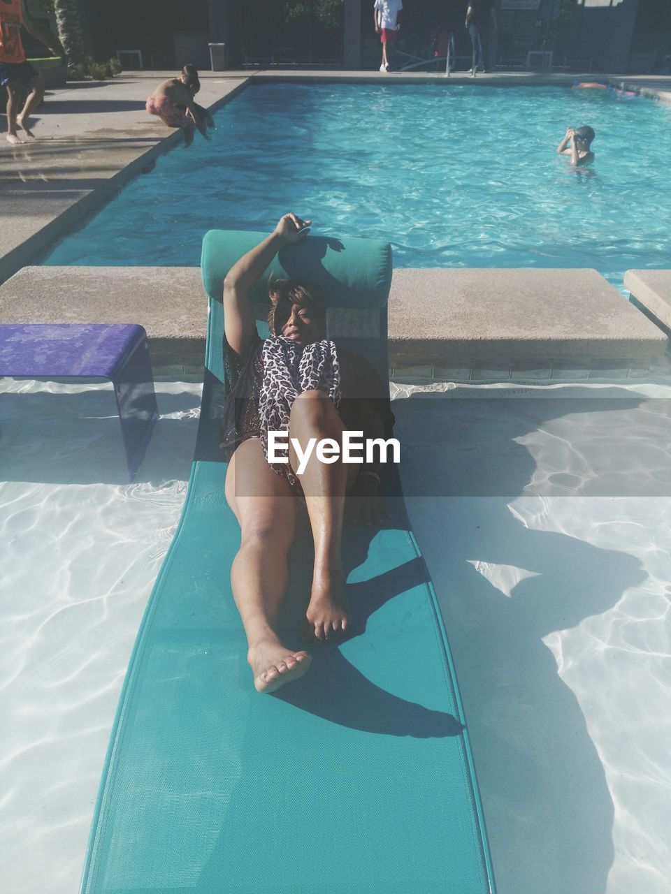 WOMAN LYING ON SWIMMING POOL