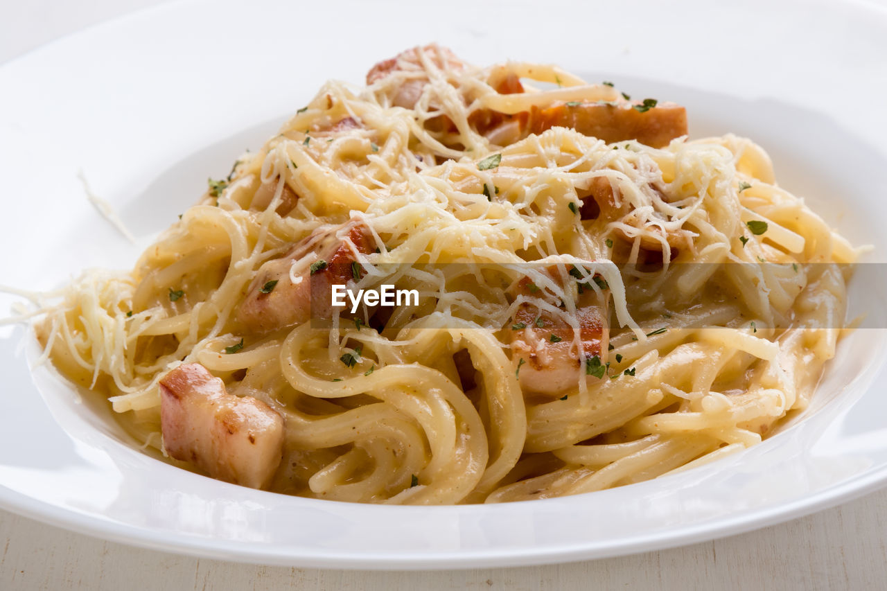 Close-up of spaghetti with carbonara in plate on table