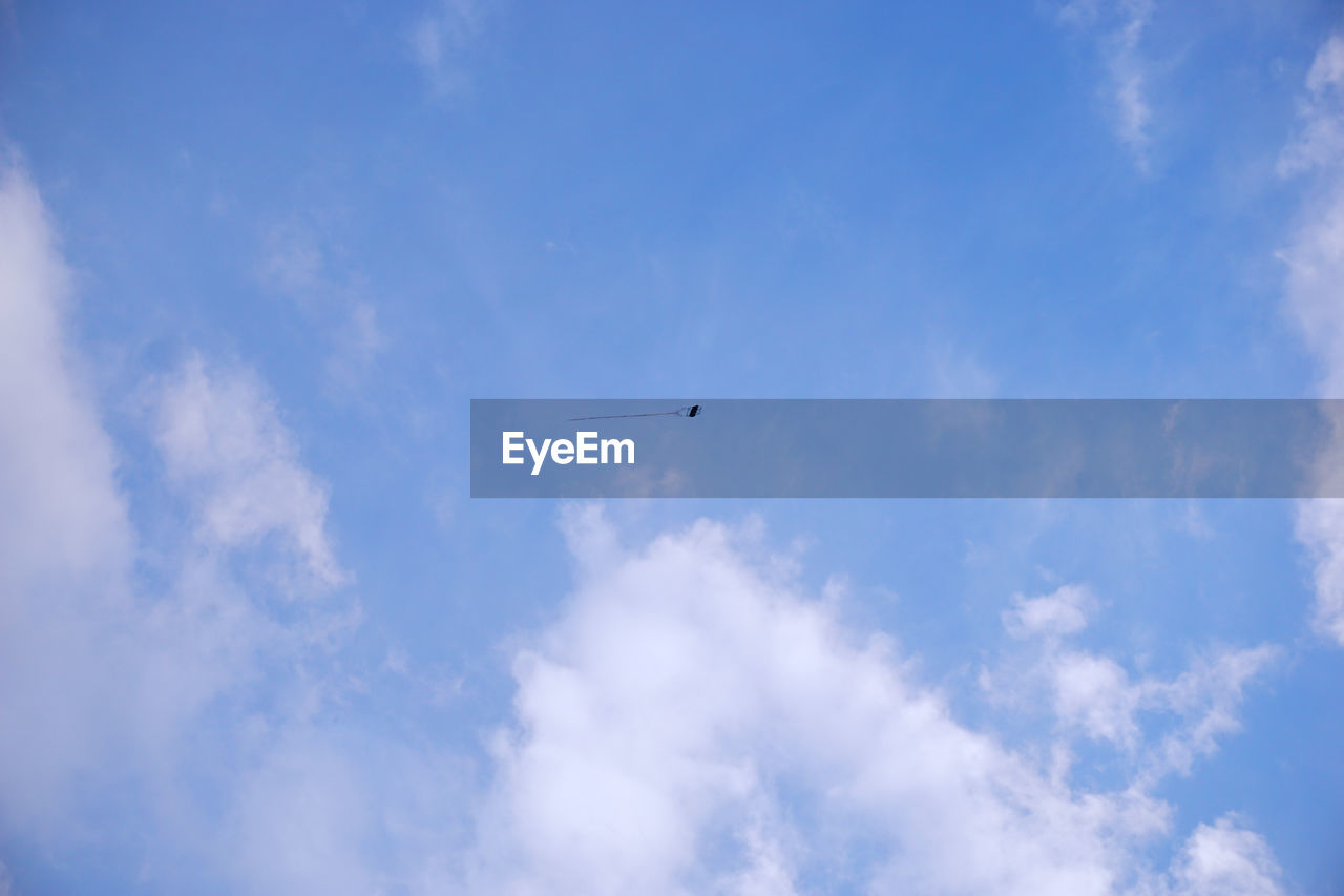 LOW ANGLE VIEW OF AIRPLANE FLYING IN BLUE SKY