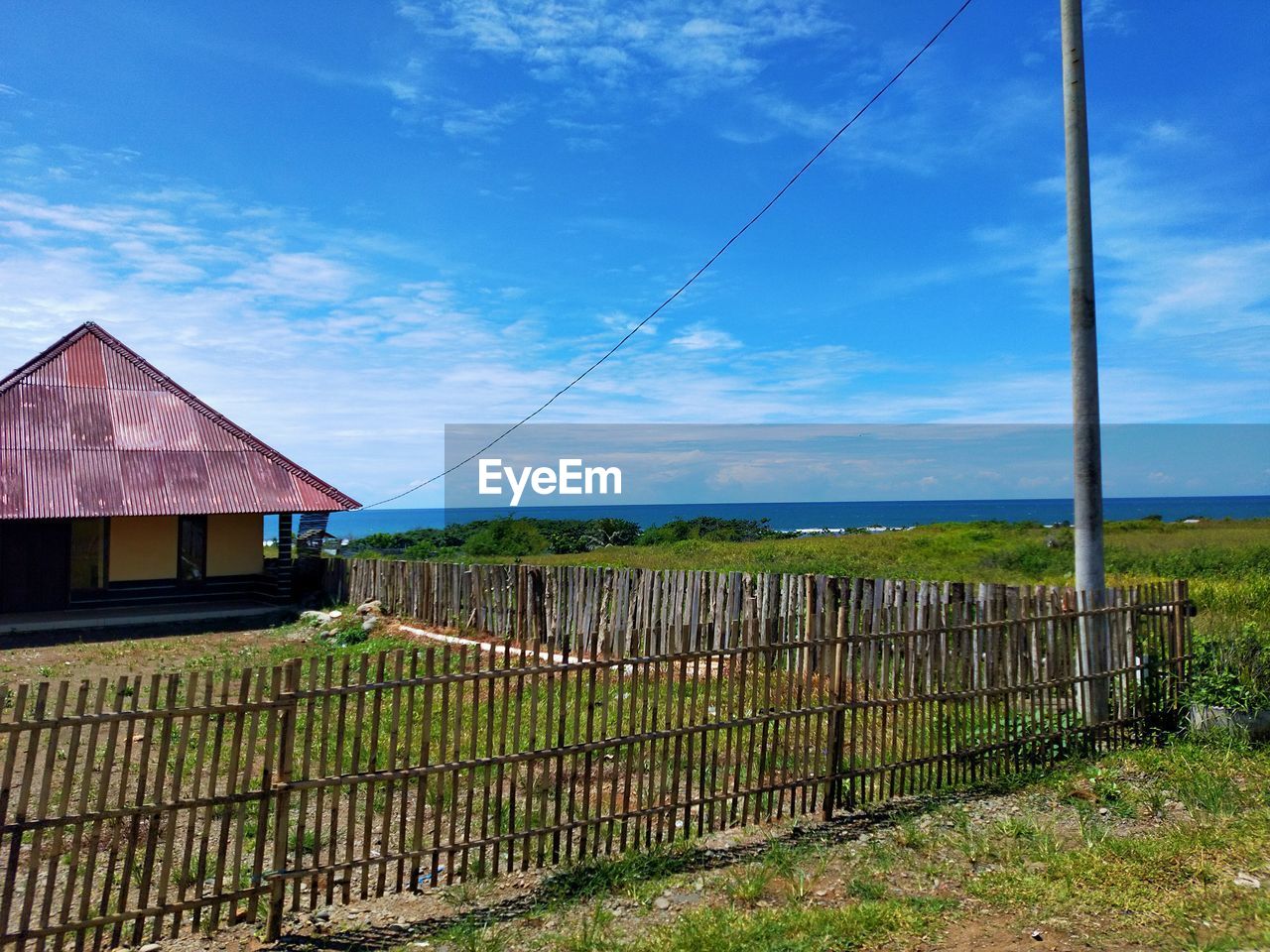 HOUSE ON FIELD AGAINST SKY