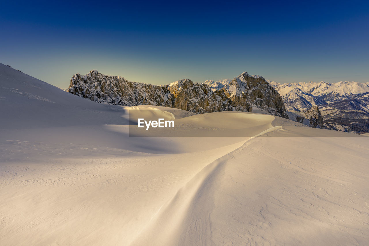 Snowcapped mountain against clear sky during winter