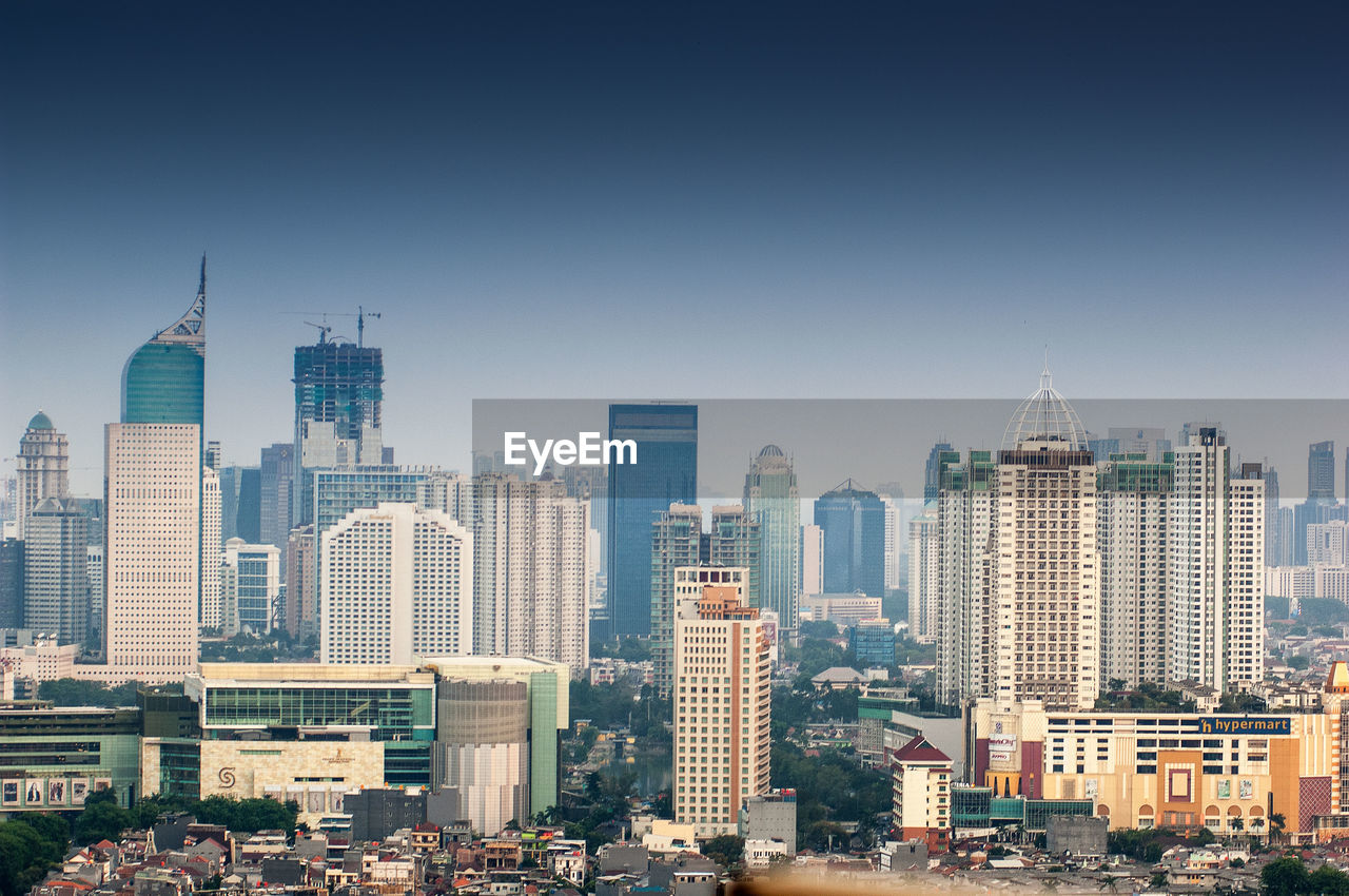 Modern buildings in city against clear sky