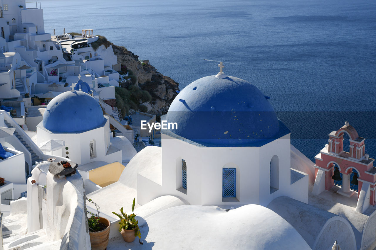 HIGH ANGLE VIEW OF WHITE BUILDINGS BY SEA AGAINST SKY