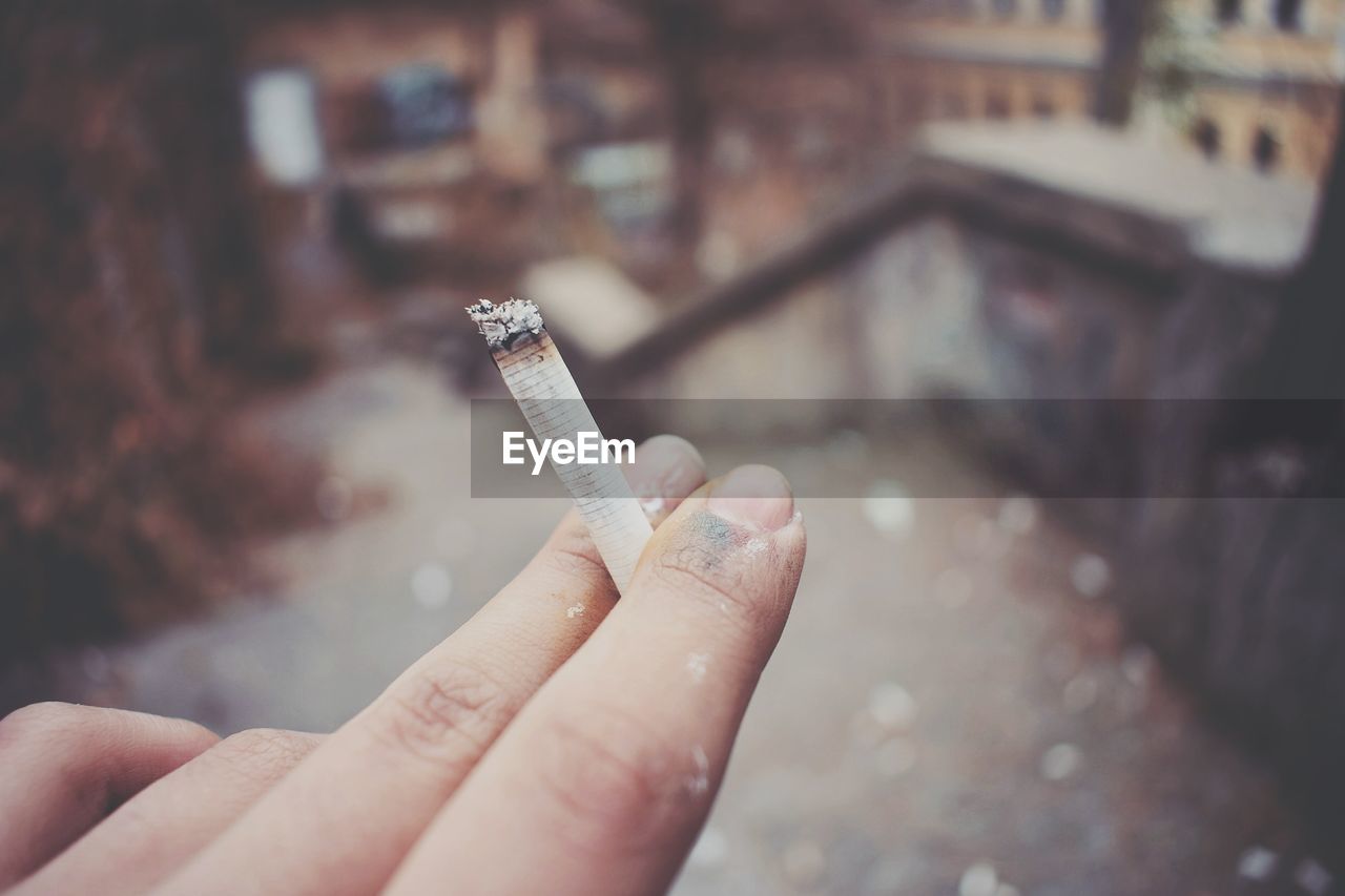 CLOSE-UP OF WOMAN HOLDING CIGARETTE