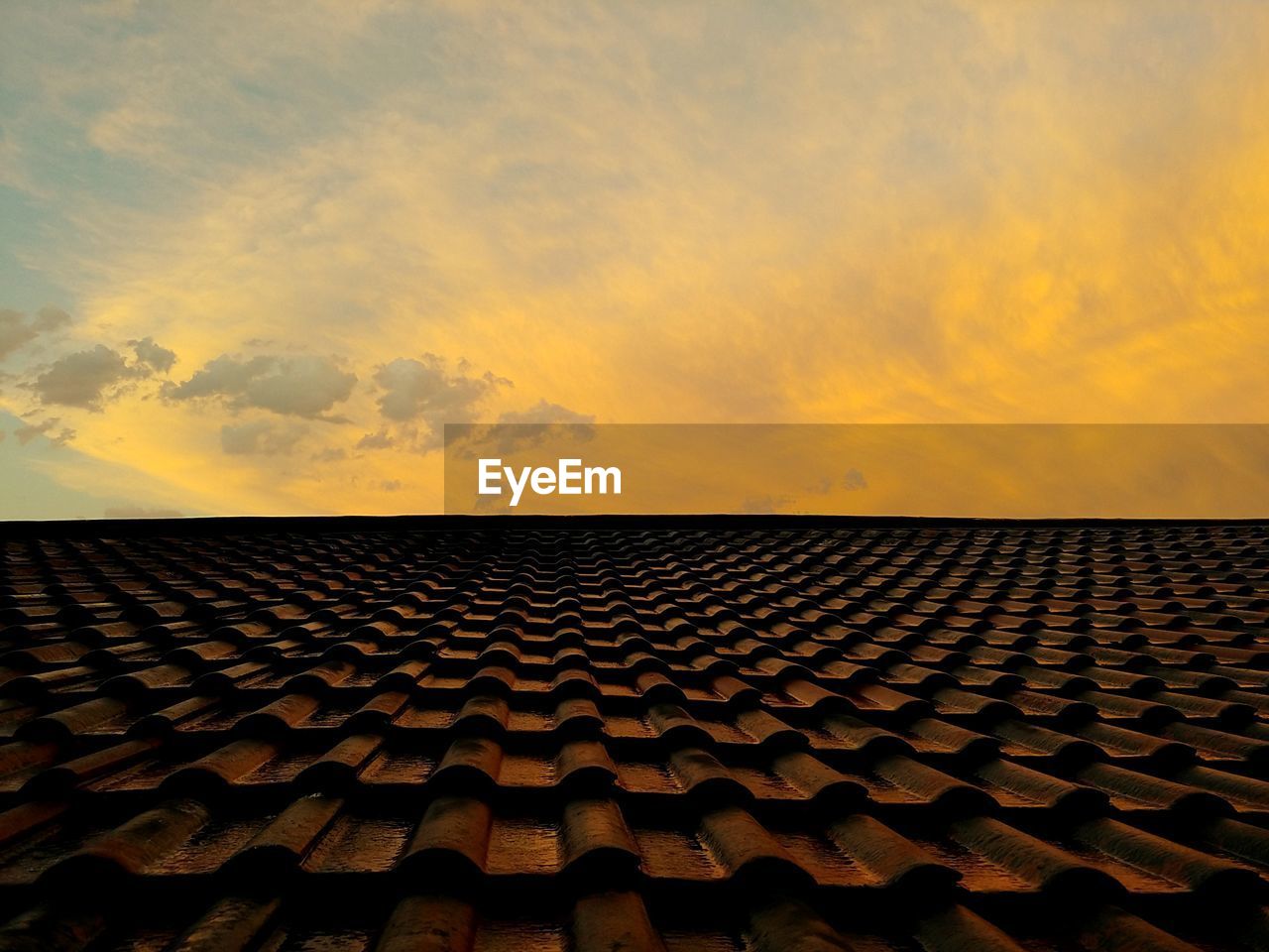 A view of passing storm clouds just before sunset from the top of a tiled roof in johannesburg. 