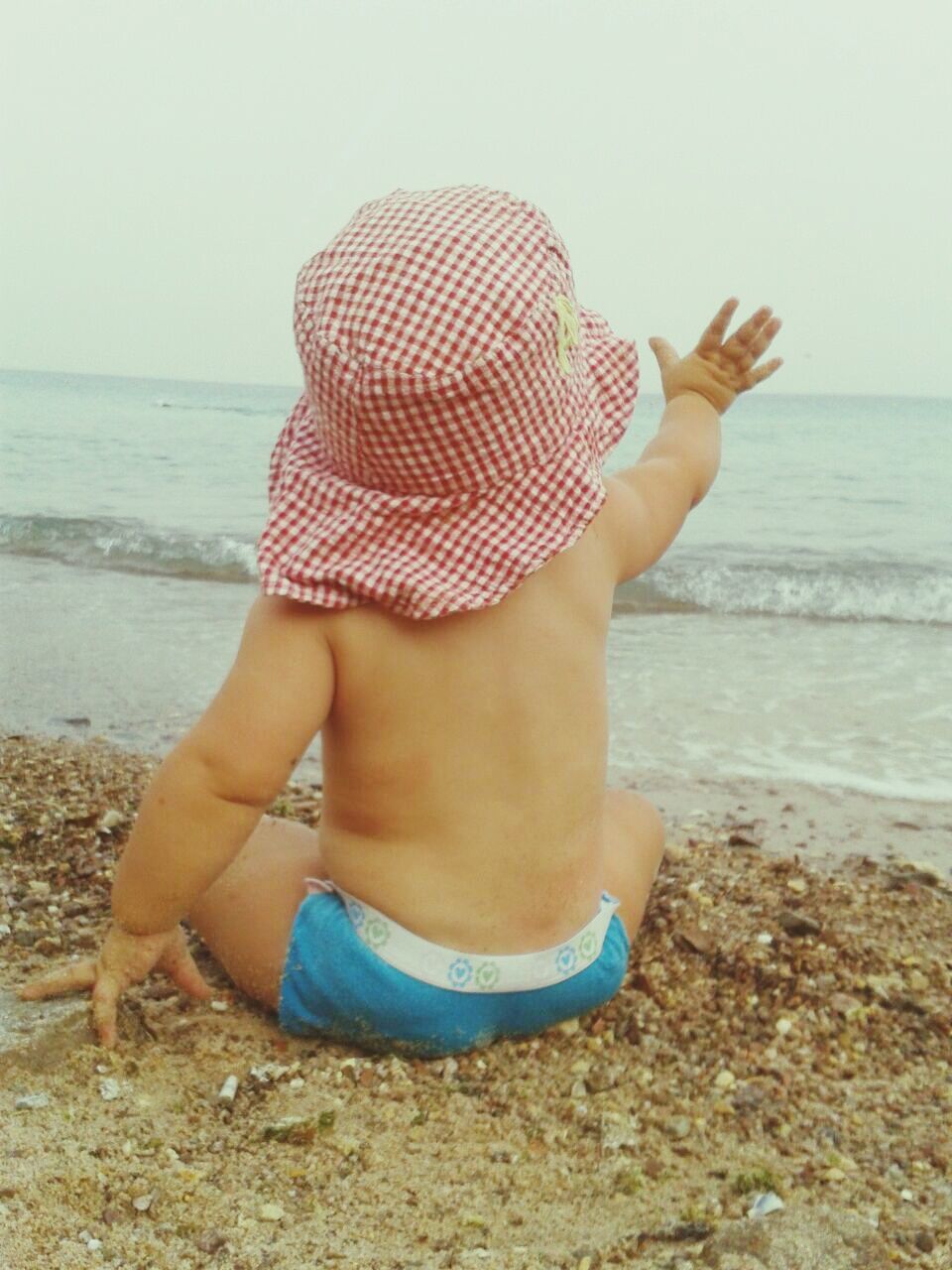 Rear view of a boy sitting on beach