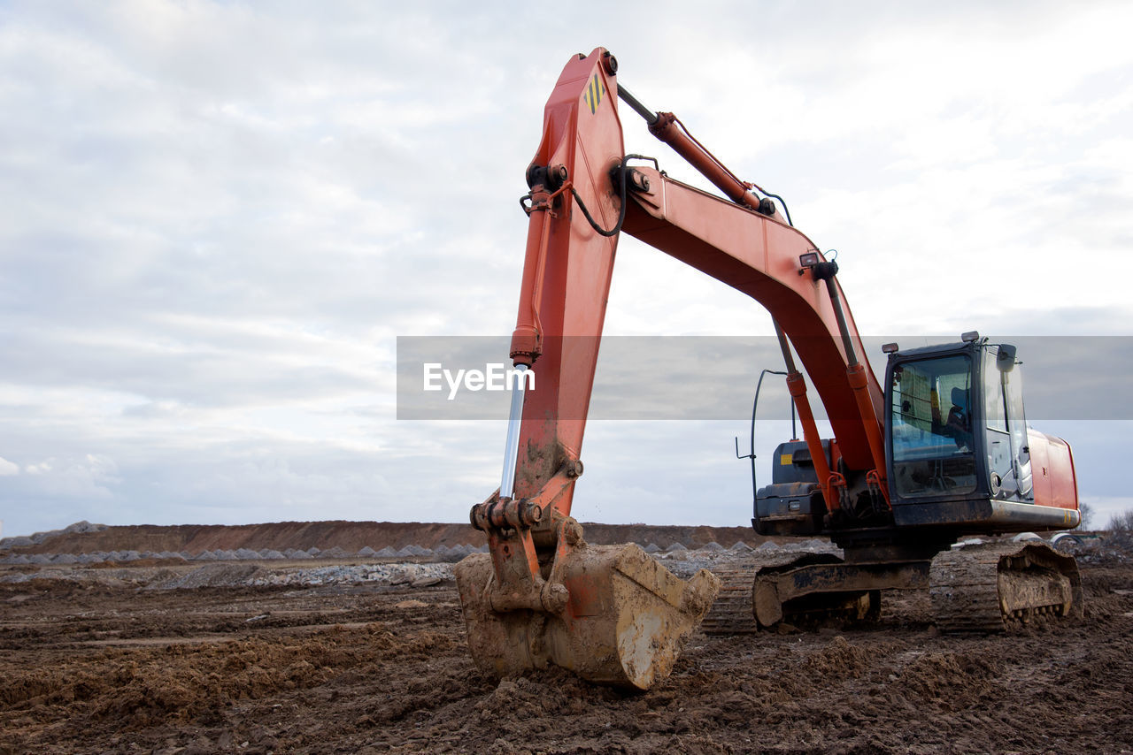 Red excavator during earthworks at construction site. backhoe digging the ground for the foundation