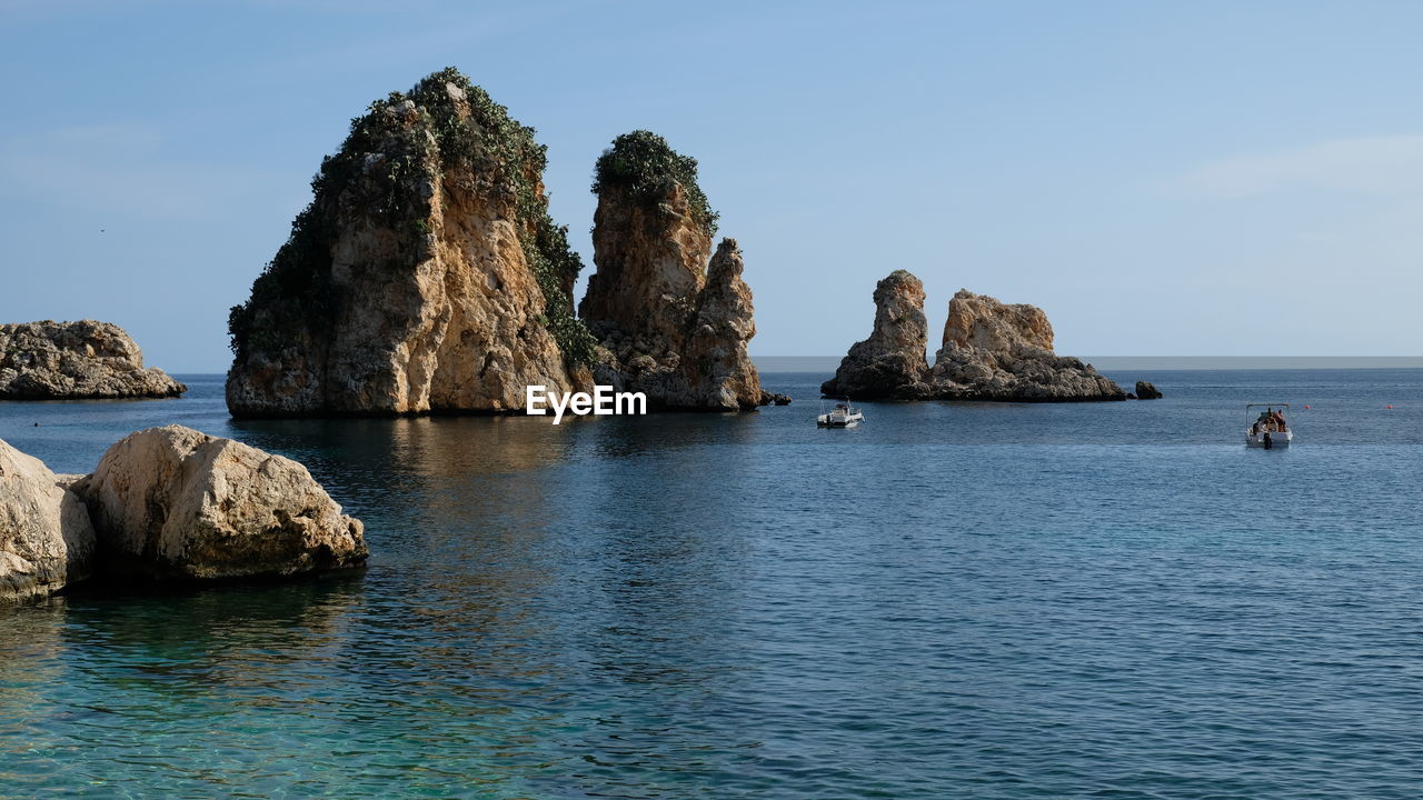 SCENIC VIEW OF ROCKS IN SEA AGAINST SKY