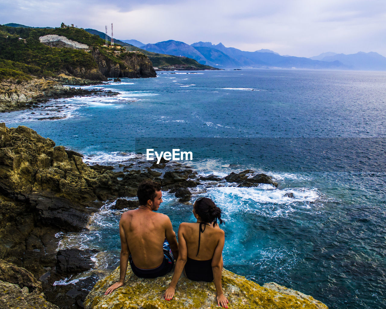 Rear view of couple looking at sea against sky