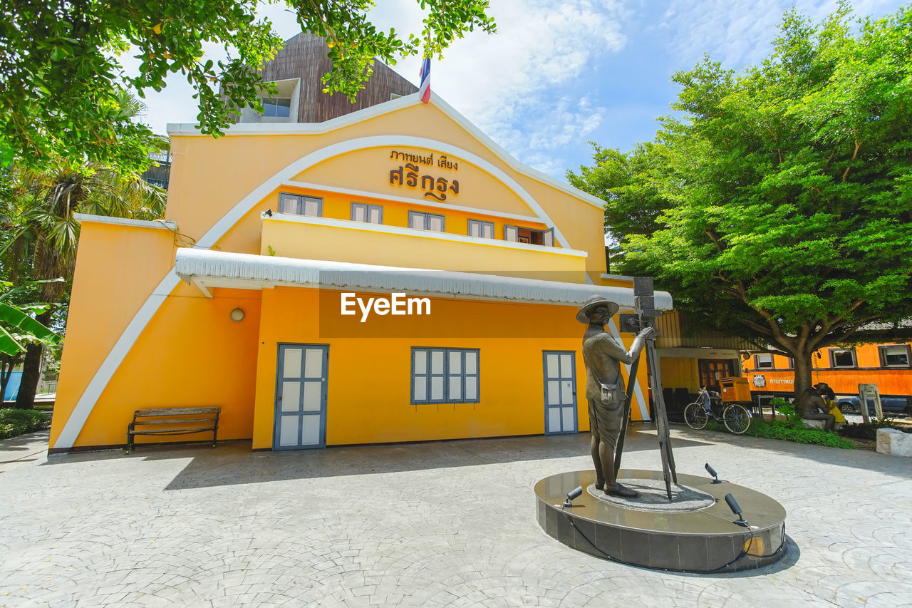 YELLOW HOUSE AGAINST TREES AND PLANTS