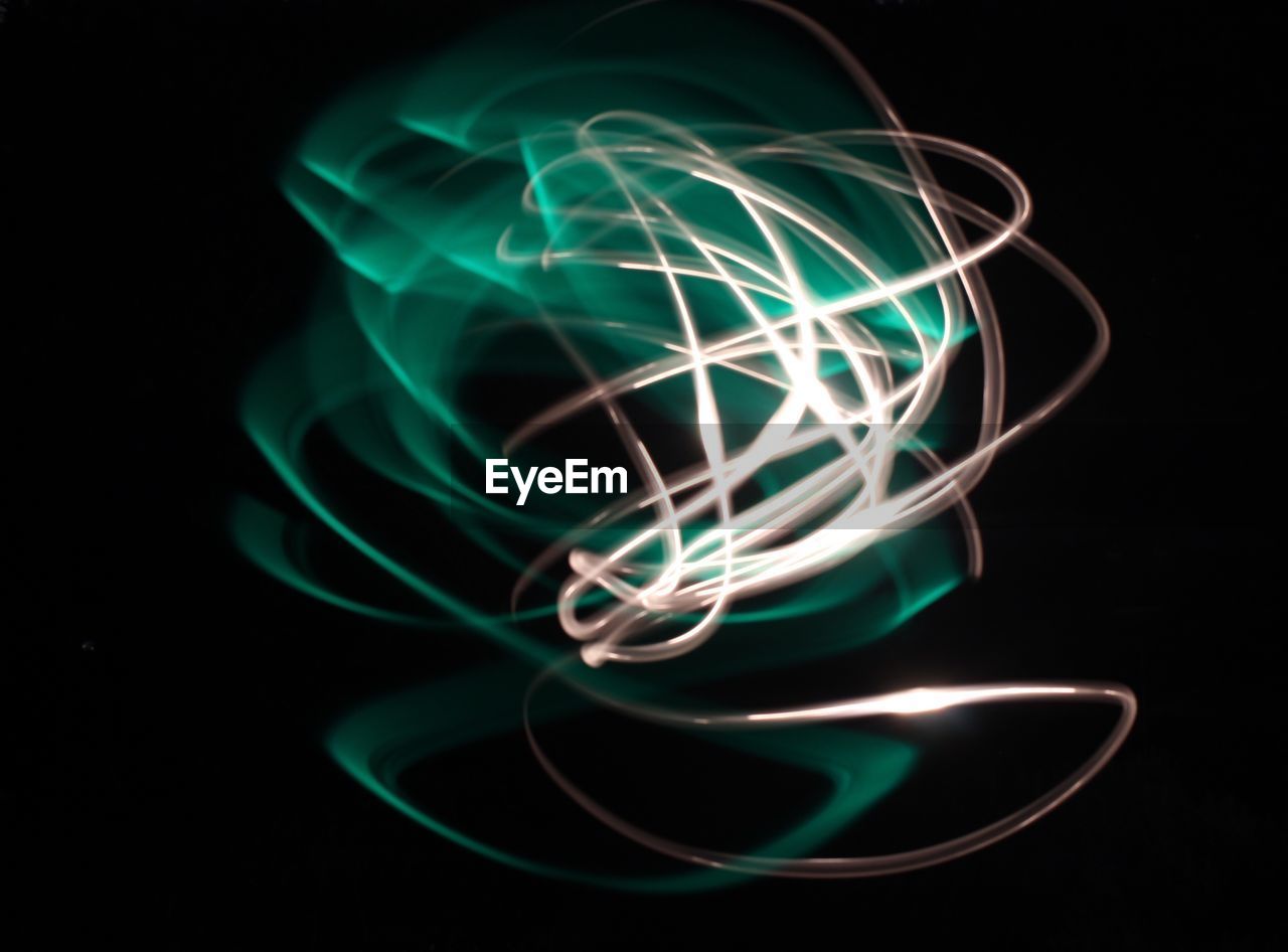 CLOSE-UP OF LIGHT TRAILS AGAINST BLACK BACKGROUND