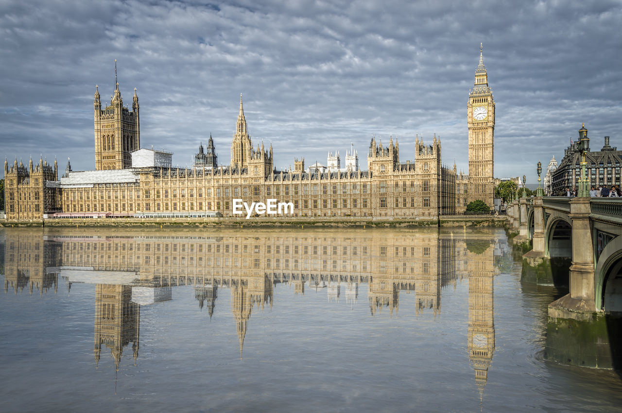 Palace of westminster and big ben reflected on thames river in city