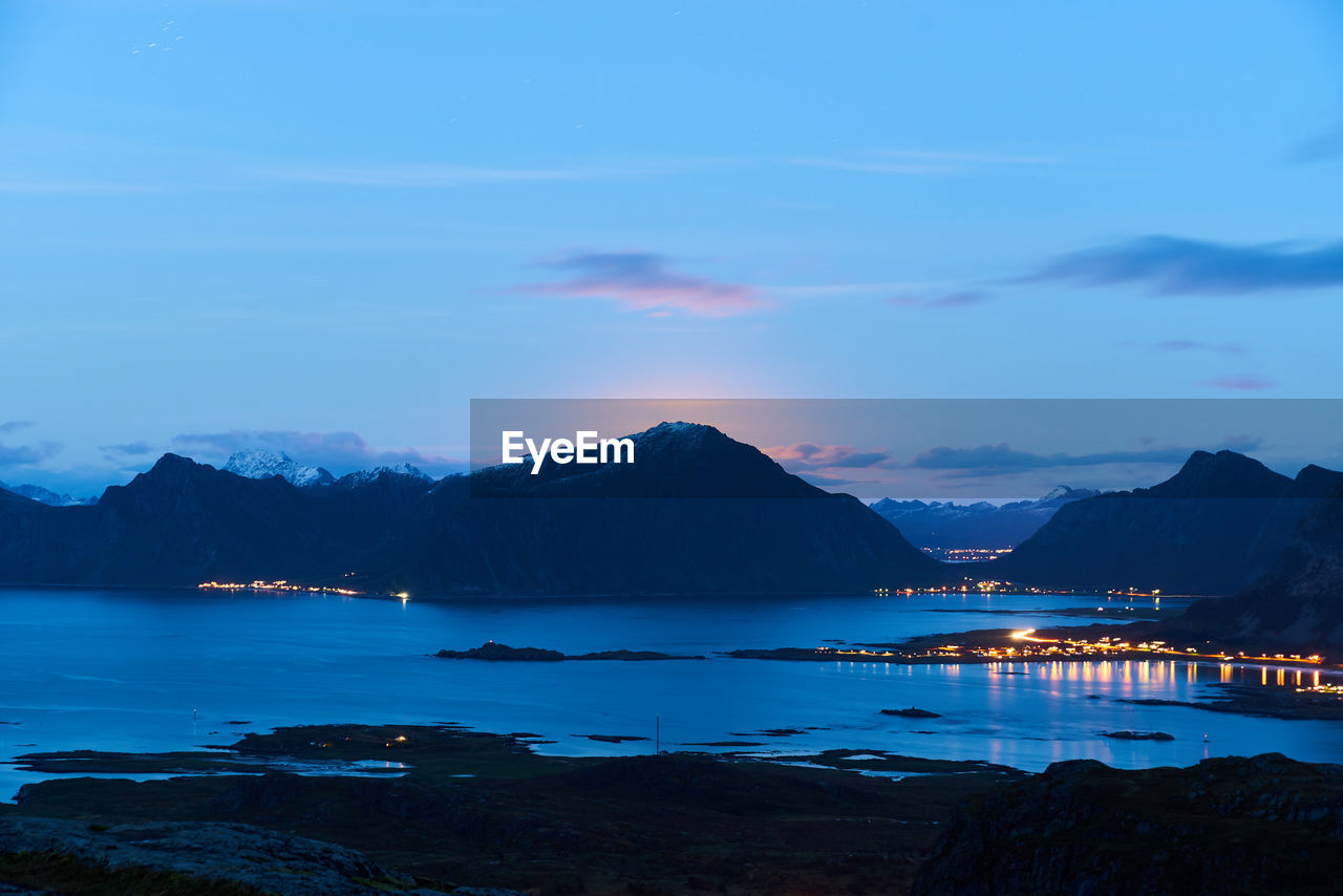 Scenic view of sea and mountains against sky at sunset