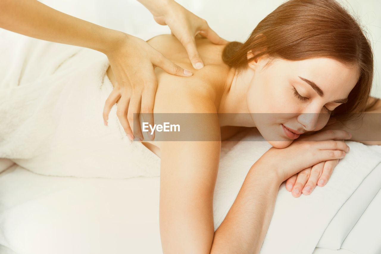Cropped image of therapist massaging woman at spa