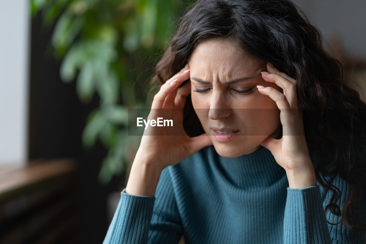Anxiety disorder. stressed worried young woman with closed eyes suffering from headache or migraine