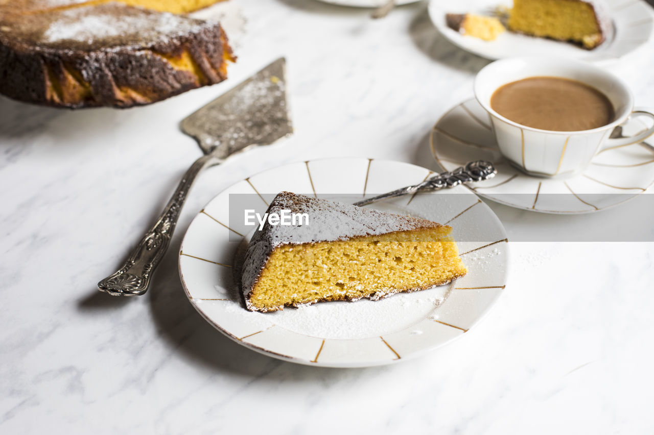 Slice of gluten free orange cake and cup of coffee