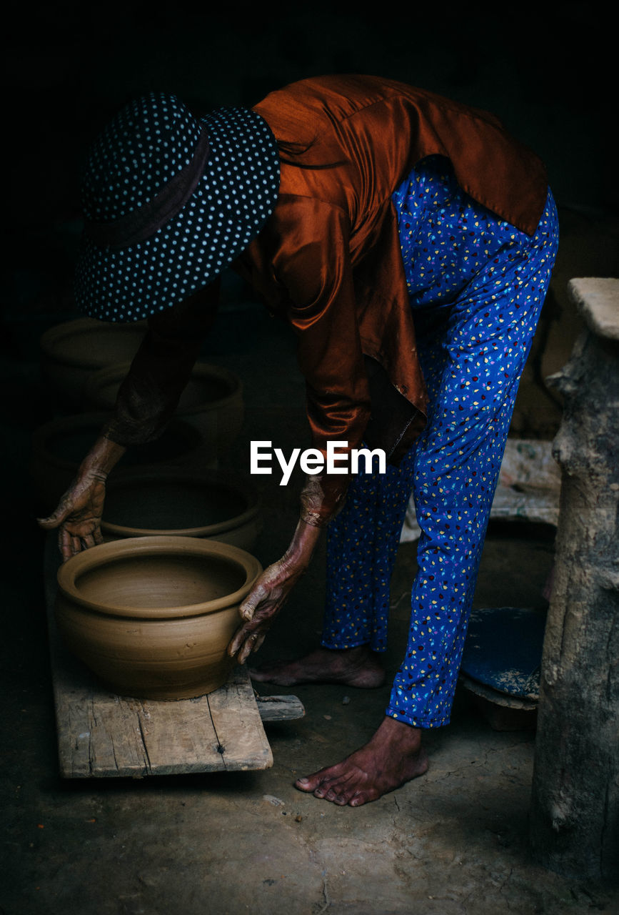 Side view of woman picking container at home