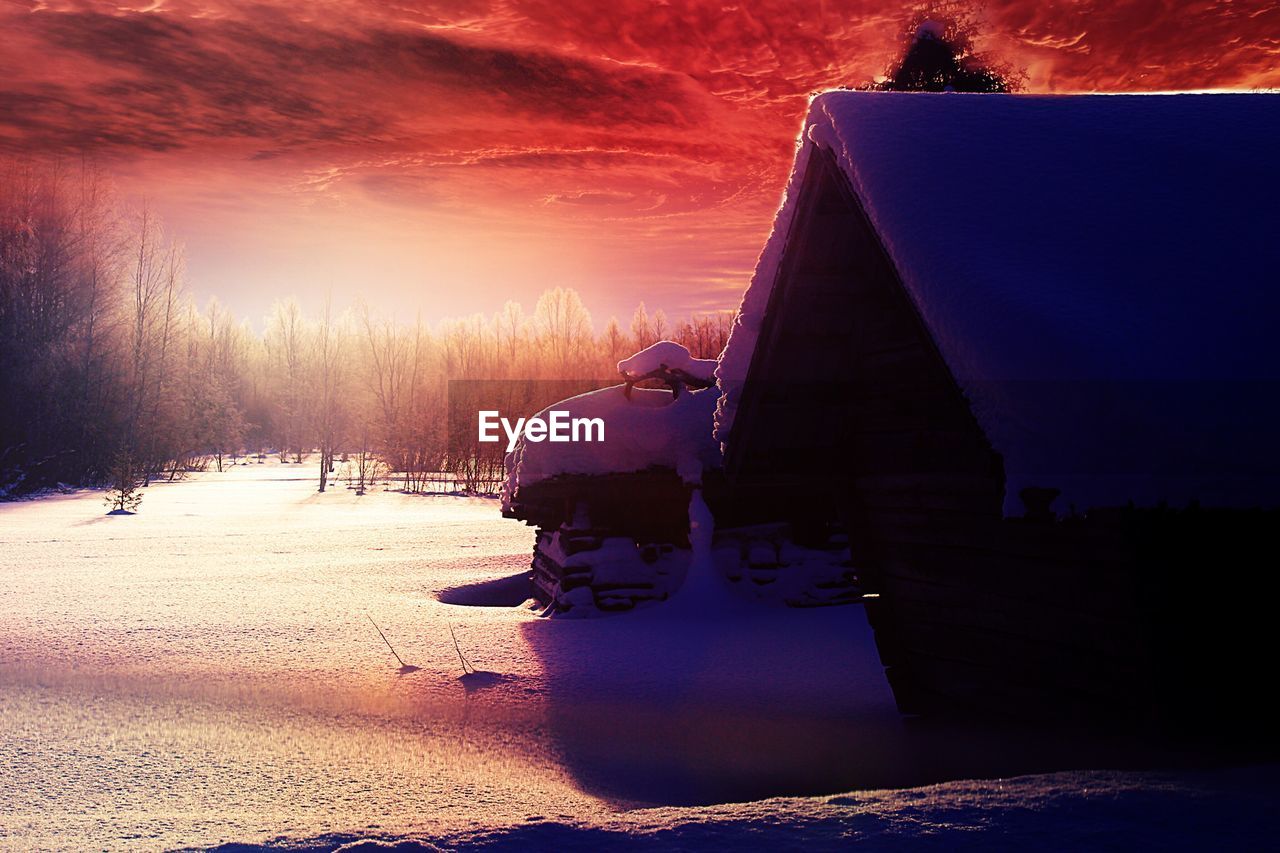 PEOPLE IN WINTER LANDSCAPE AGAINST SKY DURING SUNSET