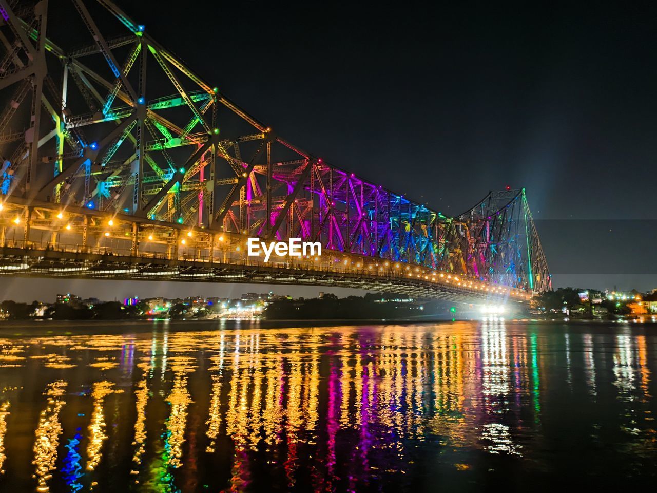 Illuminated bridge over river at night