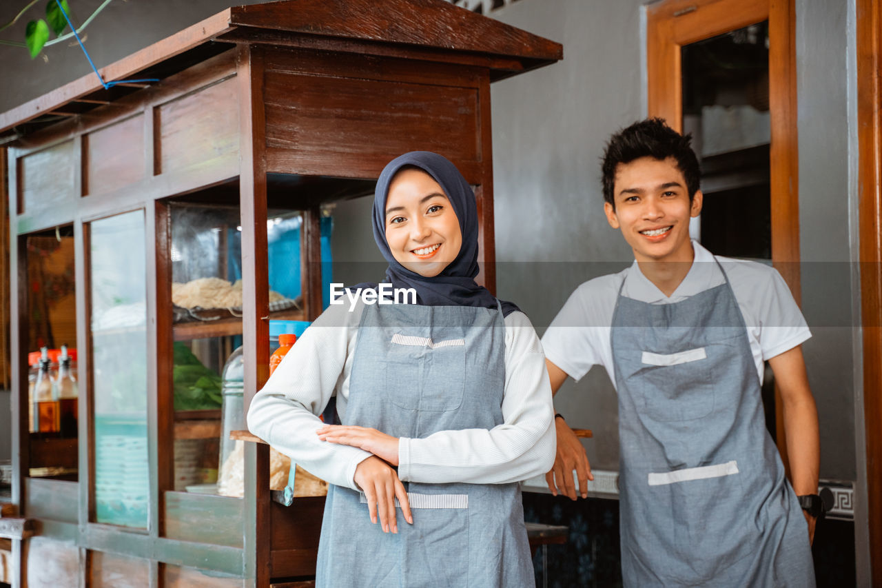 portrait of smiling young woman standing in store