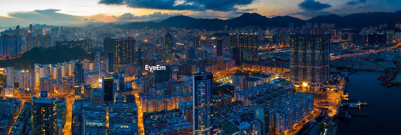 HIGH ANGLE VIEW OF ILLUMINATED CITY BUILDINGS AGAINST SKY