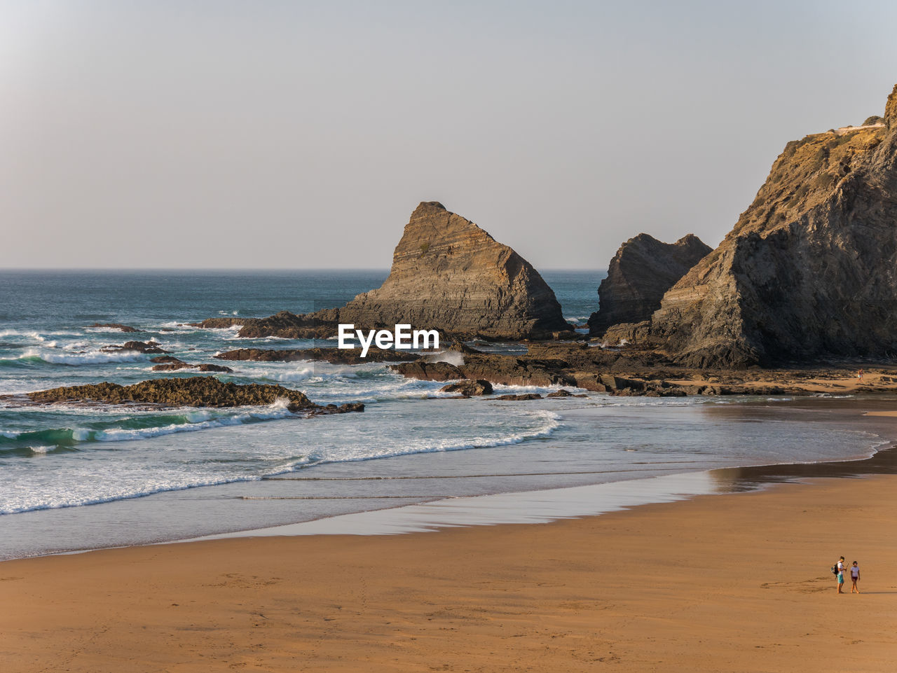 Rocks on beach against clear sky