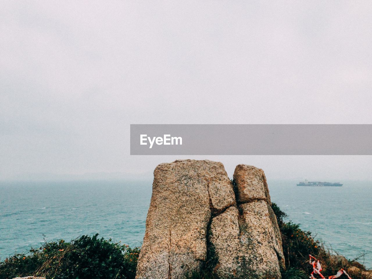 Rock formation in sea against sky