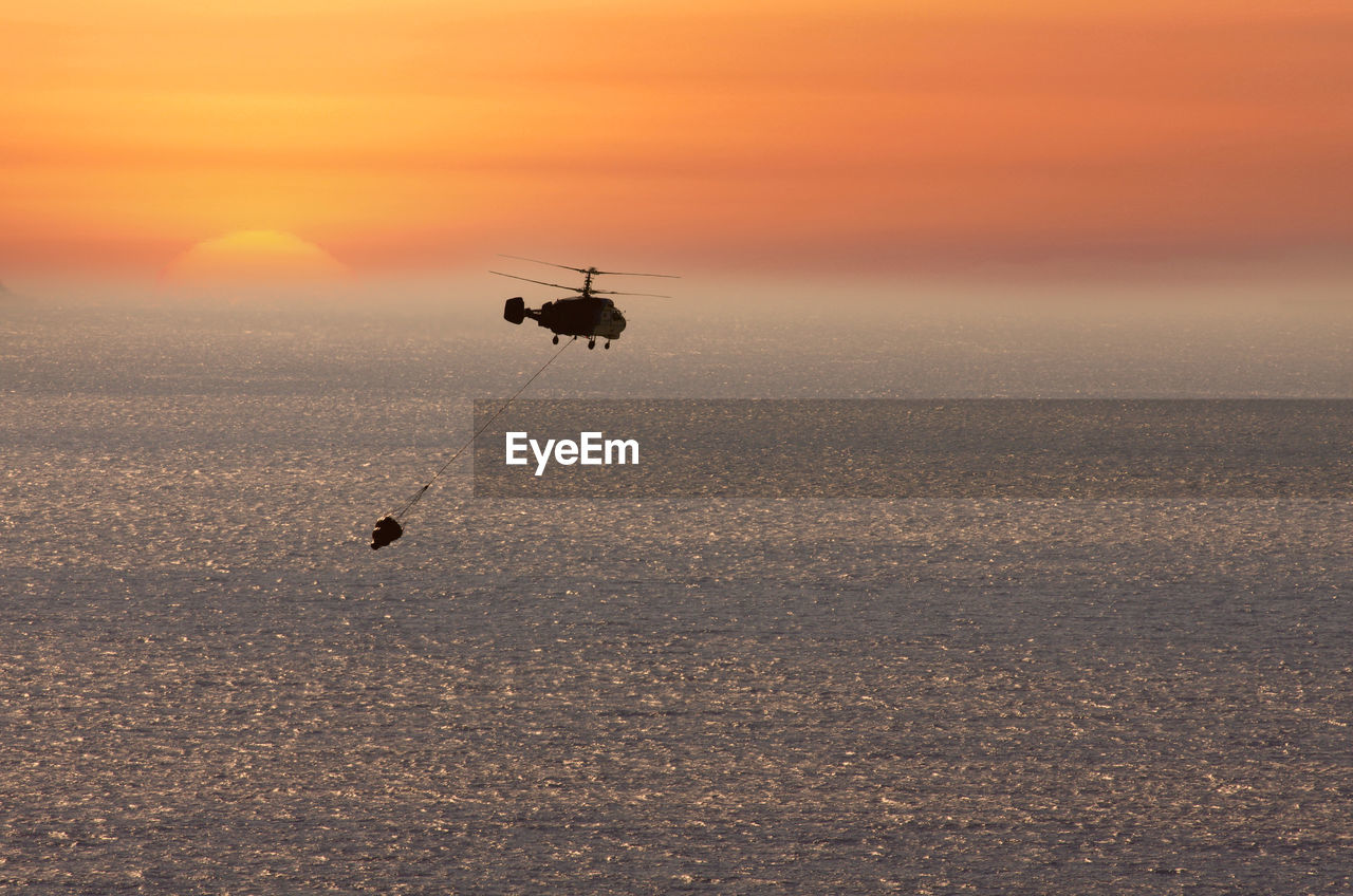 SILHOUETTE OF HELICOPTER IN SEA