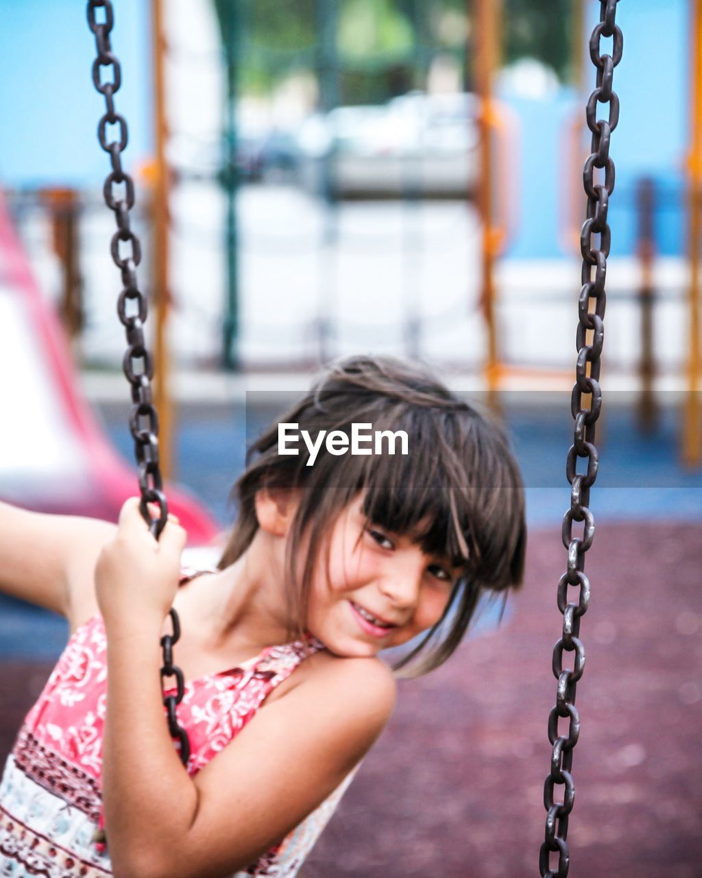 Portrait of girl swinging in playground