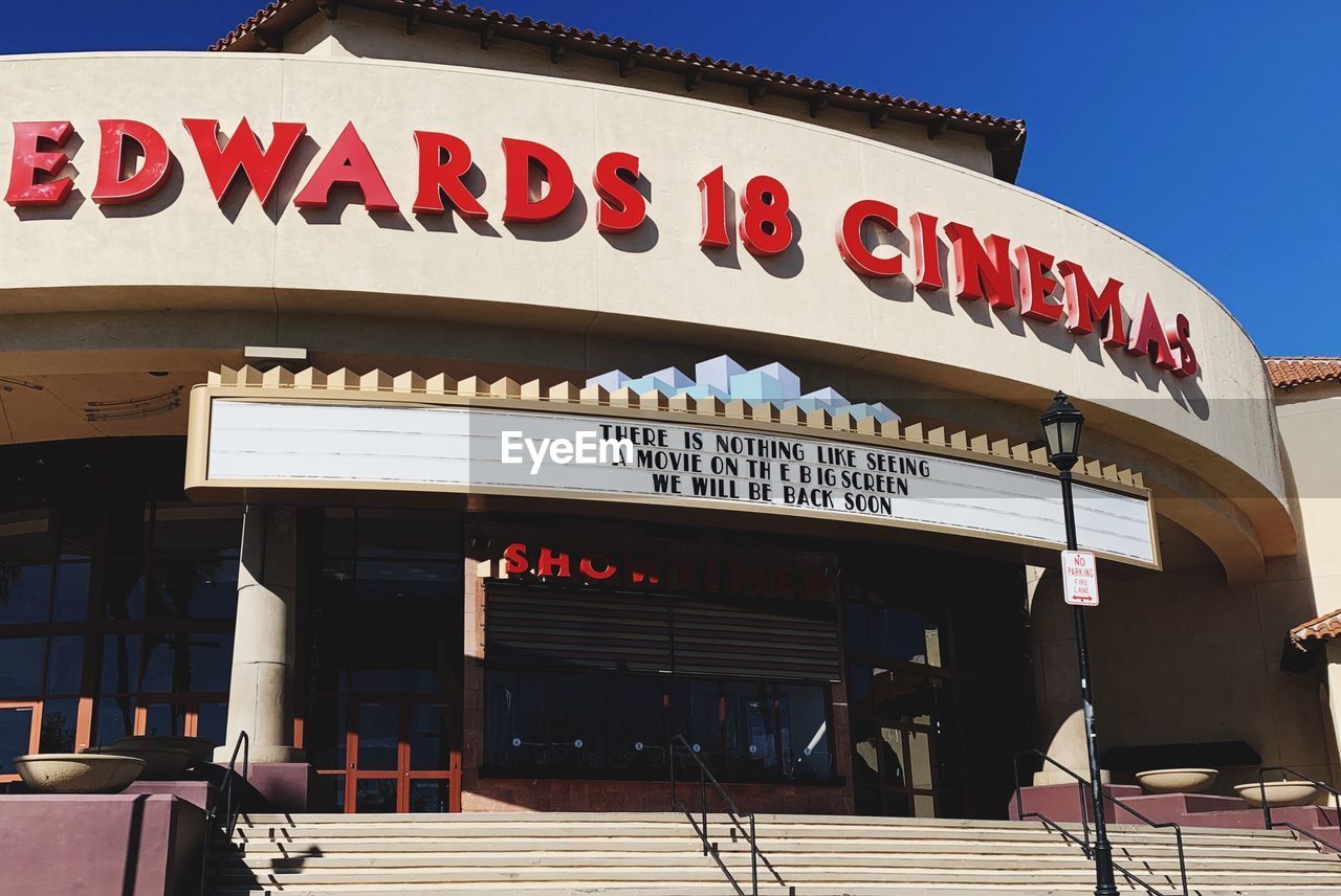 LOW ANGLE VIEW OF TEXT ON BUILDING AGAINST CLEAR SKY