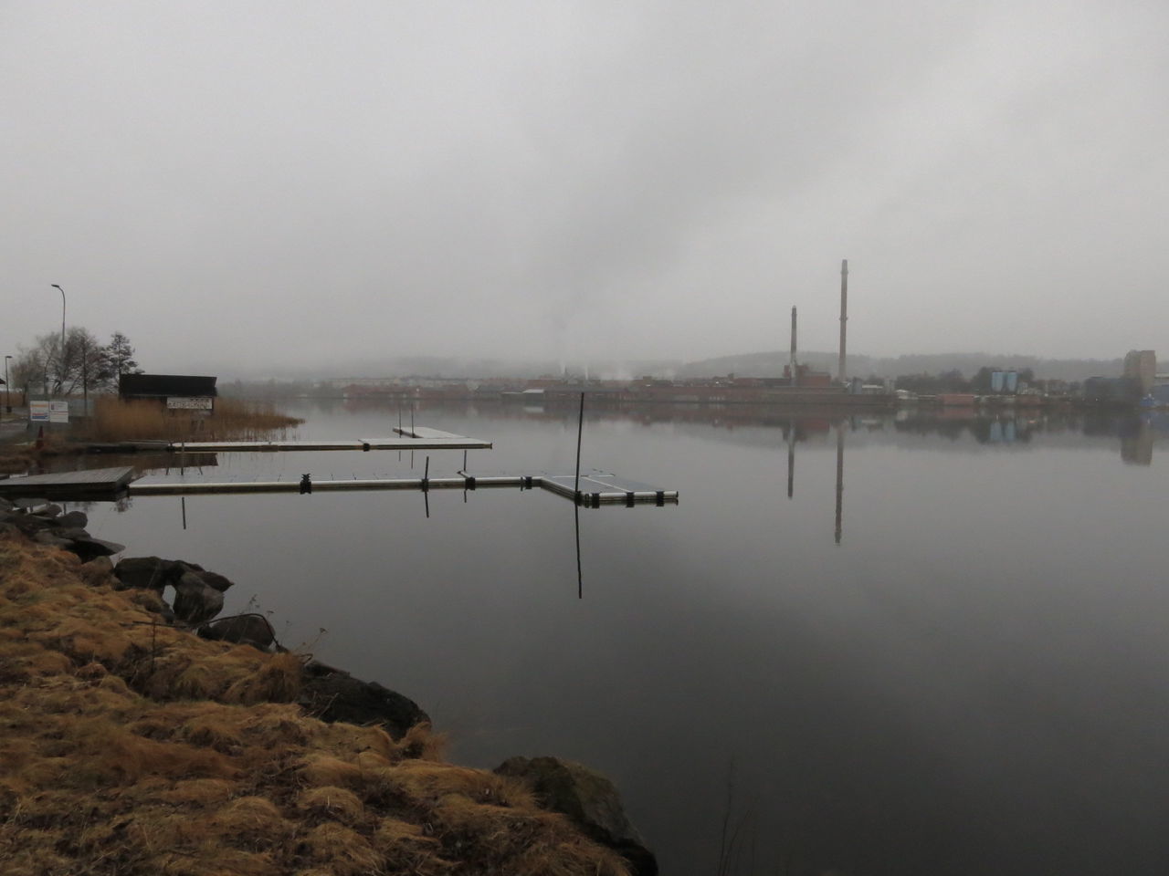 Piers in river with commercial dock in background