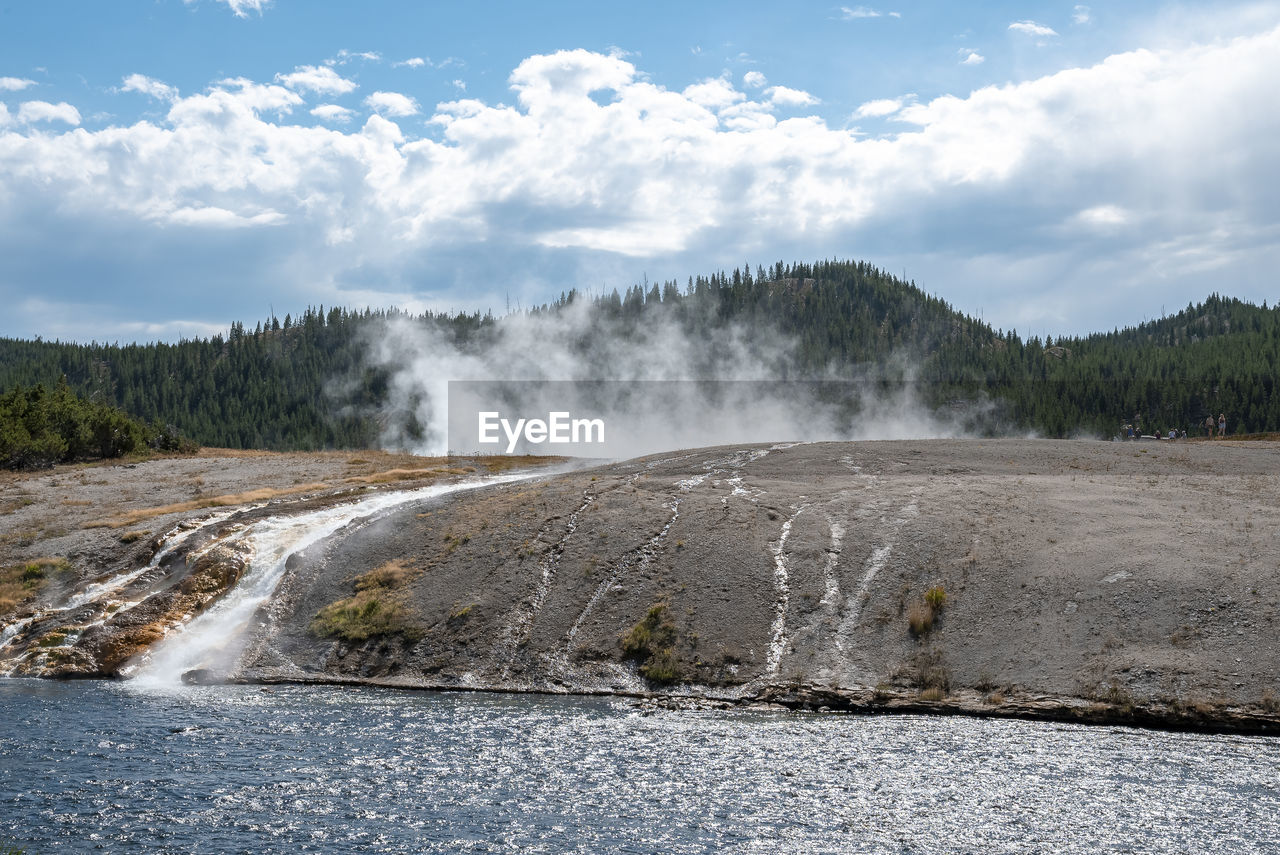 Smoke emitting from hotspring in midway geyser basin by firehole river at park