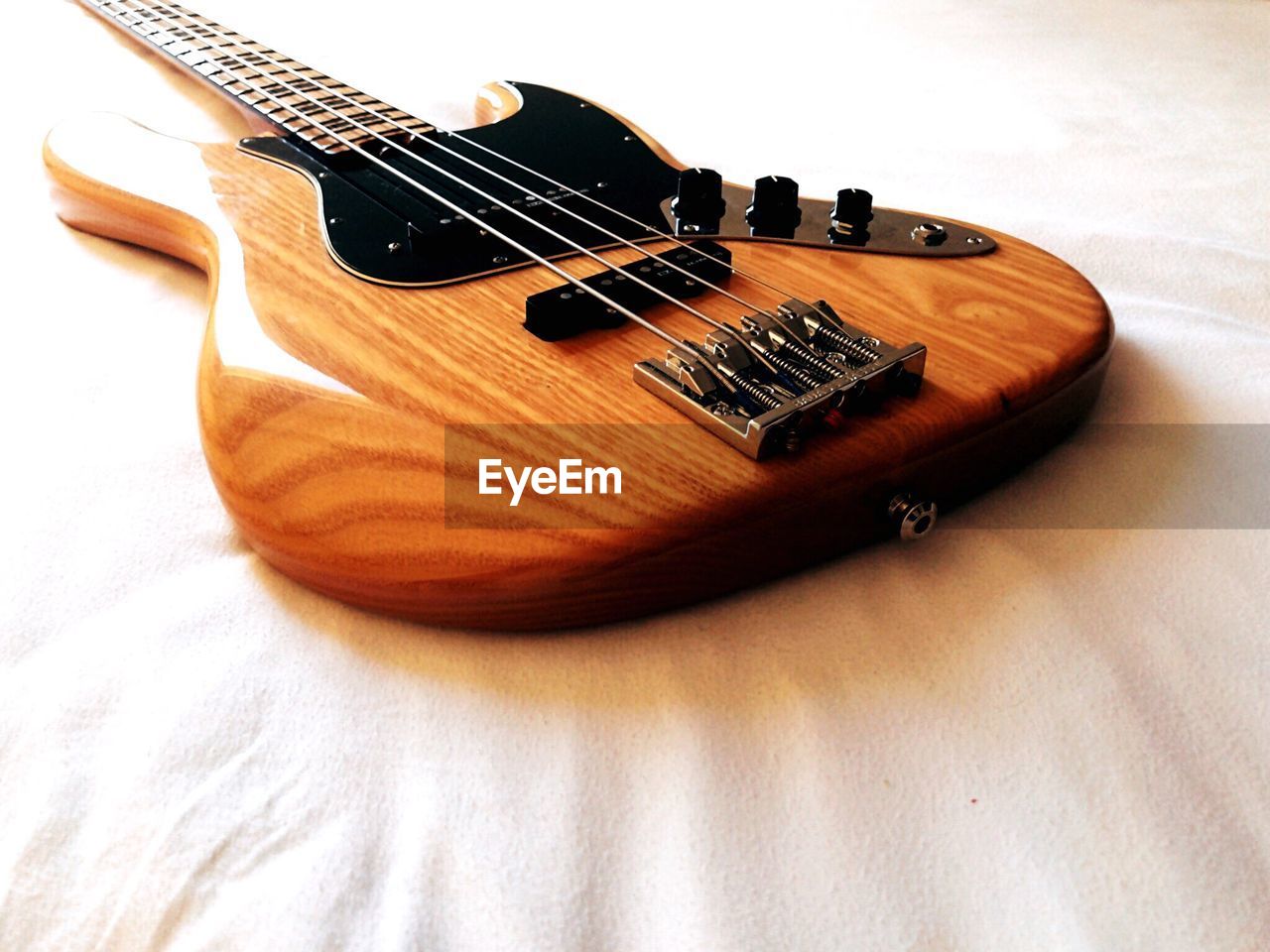 Close-up of guitar on bed