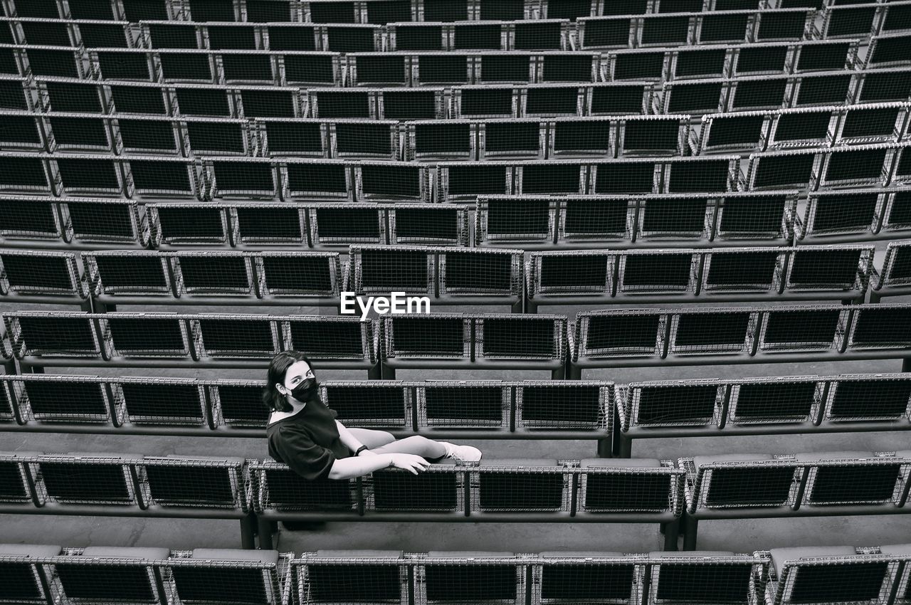 High angle view of girl sitting on seats in stadium