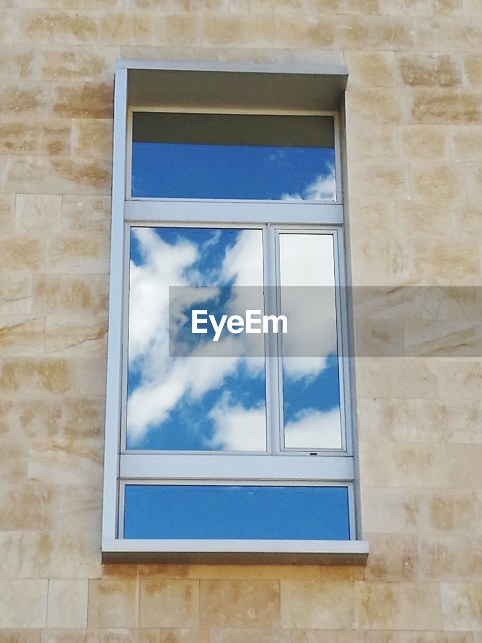 LOW ANGLE VIEW OF BLUE SKY SEEN THROUGH WINDOW ON WALL