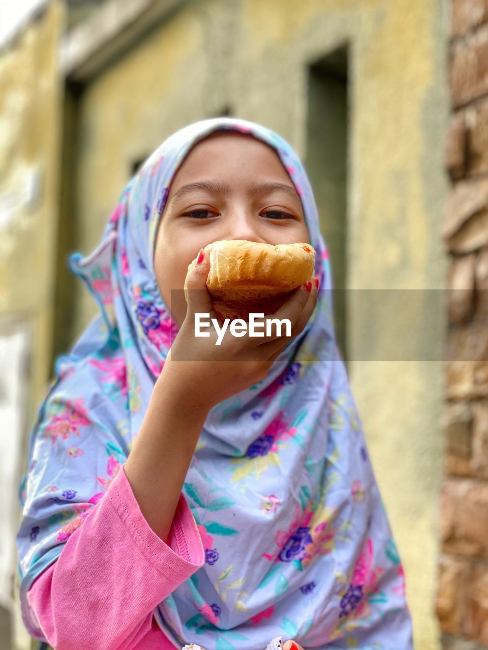 Portrait of an asian girl eating bread