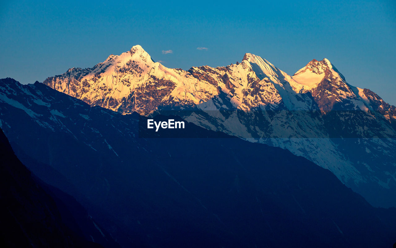 Scenic view of snowcapped mountains against clear sky