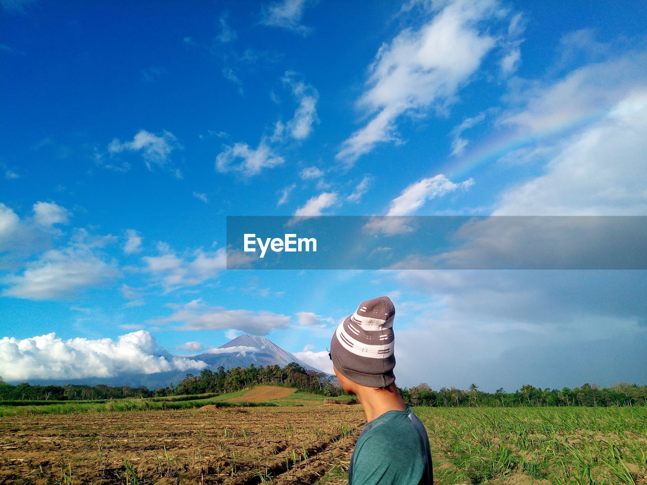 Man wearing hat while standing on agricultural field
