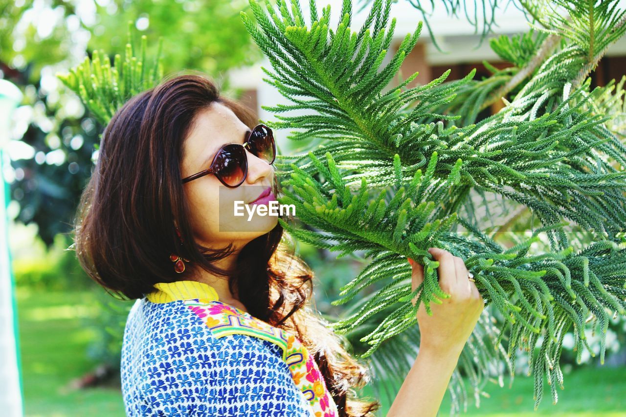 Woman standing by pine tree at park